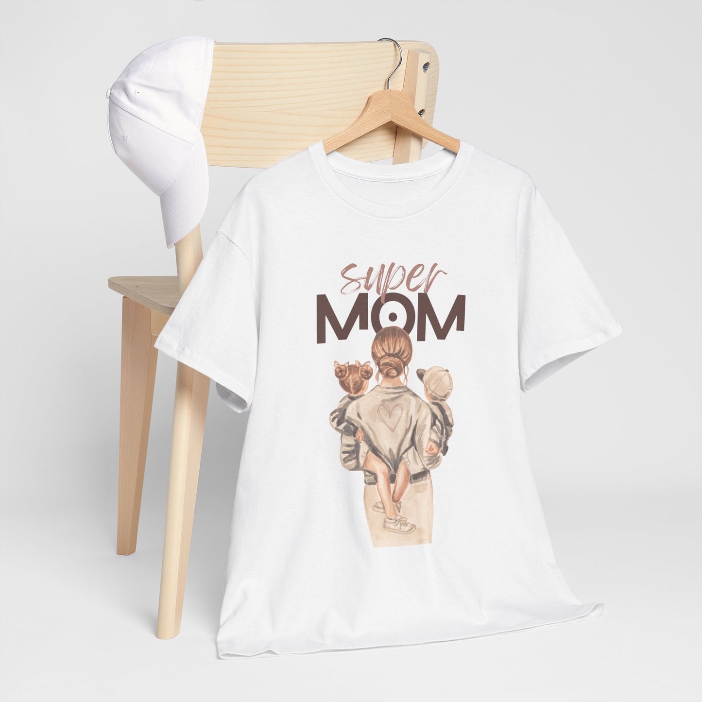 White celebration shirt for moms with super mom graphic hanging on wooden chair with white cap